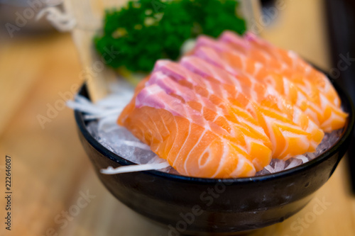Salmon sashimi serve on ice in bowl.