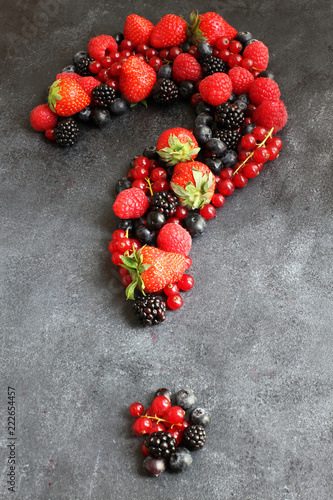 Question mark of fresh berries on dark board