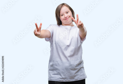Young adult woman with down syndrome over isolated background smiling looking to the camera showing fingers doing victory sign. Number two.