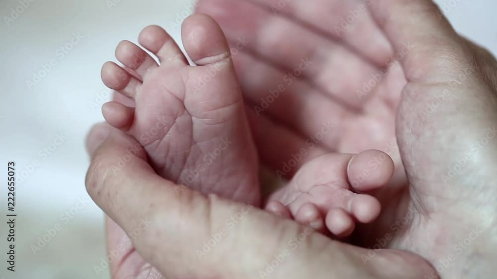 Hands of mother with little baby feet. One months old baby boy. Mom holds little baby feet in the hands Hands of mother with little baby feet. One months old baby boy. Mom holds little baby feet in the hands