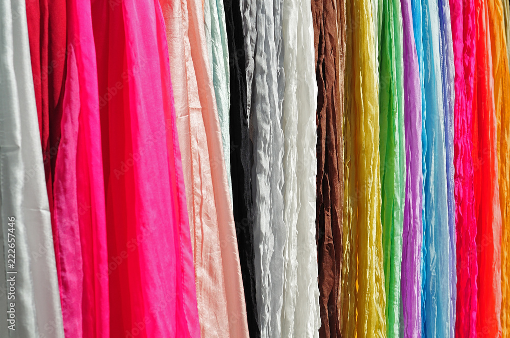 colorful silk shawls hanging on display stand