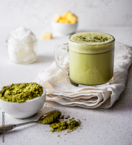 BULLETPROOF MATCHA. Ketogenic keto diet hot drink. Tea matcha blended with coconut oil and butter. Cup of bulletproof matcha and ingredients on white background