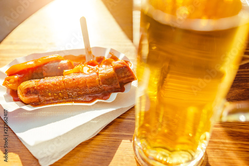 Fotografie Curry wurst Sausages with beer on the table in outdoor restaurant