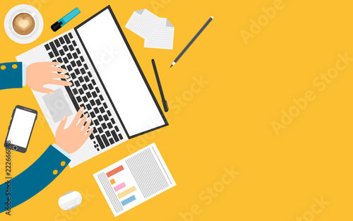 Freelance workplace top view. Laptop, papers, notes, mobile phone and cup of coffee. Man’s hands  working on the laptop. Place for text.