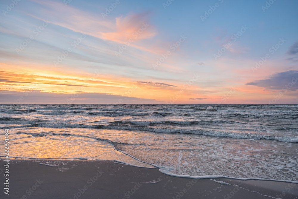 Sunset on Baltic Sea white pastel color sky and rough sea. 