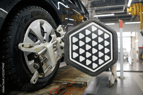 Young Vietnamese auto mechanic checking tyre in garage