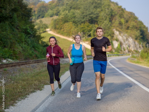 young people jogging on country road