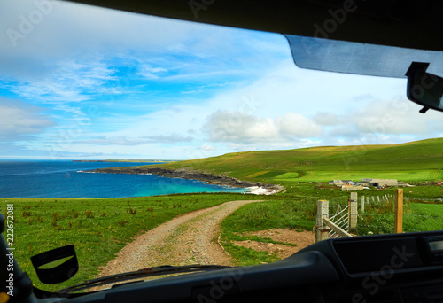 Small beach with white sand seen from the inside of a car, Orkney islands, Scotland