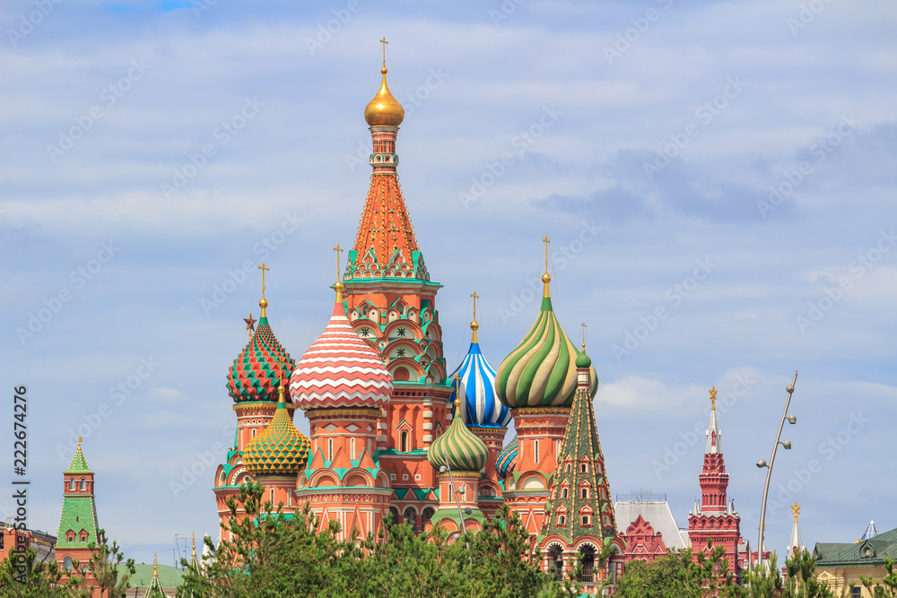 St. Basil's Cathedral on Red square in Moscow against green trees and sky with clouds on a summer day