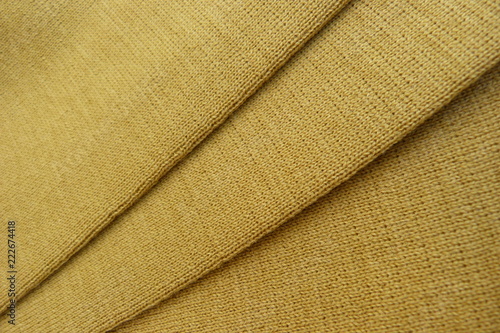 yellow knitted woolen fabric close-up natural material beige cloth for background