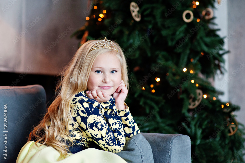 The beautiful smiling girl with a fair hair indoors with a Christmas interior The beautiful smiling girl with a fair hair indoors with a Christmas interior