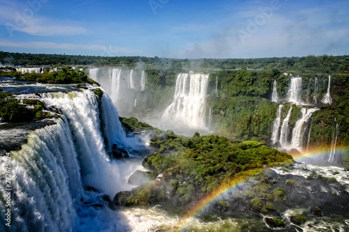 Water cascading over the Iguacu falls with rainbow in foreground in Brazil © Nigel