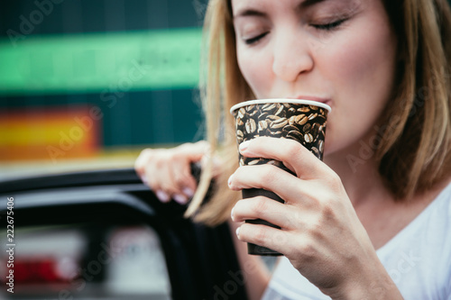 Junge fröhliche Frau trinkt Kaffee aus einem Becher photo