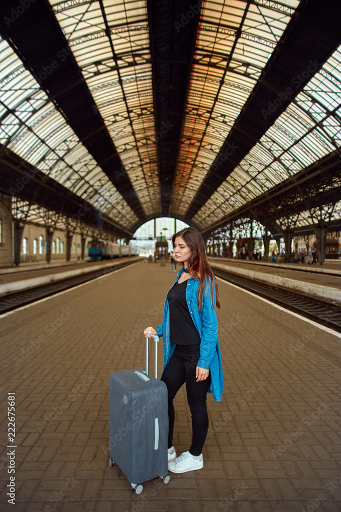 young woman with a suitcase at the train station