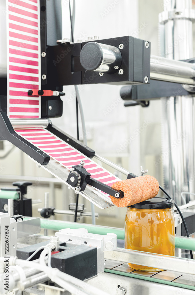 Vertical image of packing honey jars in factory. Vertical image of packing honey jars in factory.