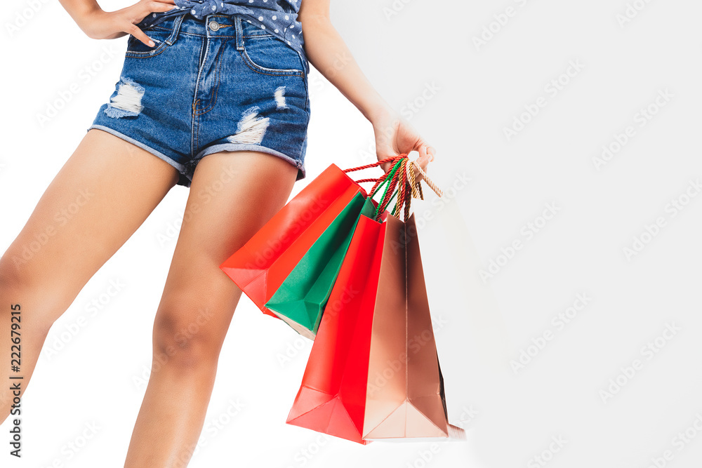 Women are happy with the shopping cart and hand holding paper bags.