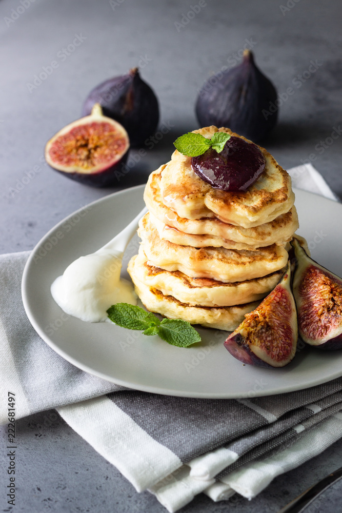 Homemade fluffy pancake with fig jam and fruits decorated with mint and natural yogurt in spoon Homemade fluffy pancake with fig jam and fruits decorated with mint and natural yogurt in spoon