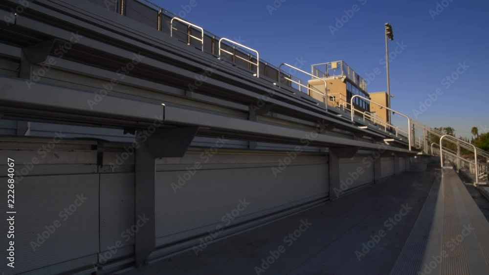 EMPTY FOOTBALL STADIUM BLEACHERS.  OUTDOORS IN 4K SLIDER SHOT