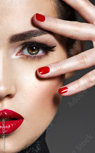 Beautiful woman with bright make-up and red nails.