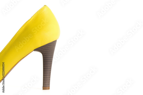 Photo of heels of yellow leather female shoes isolated on a white background.