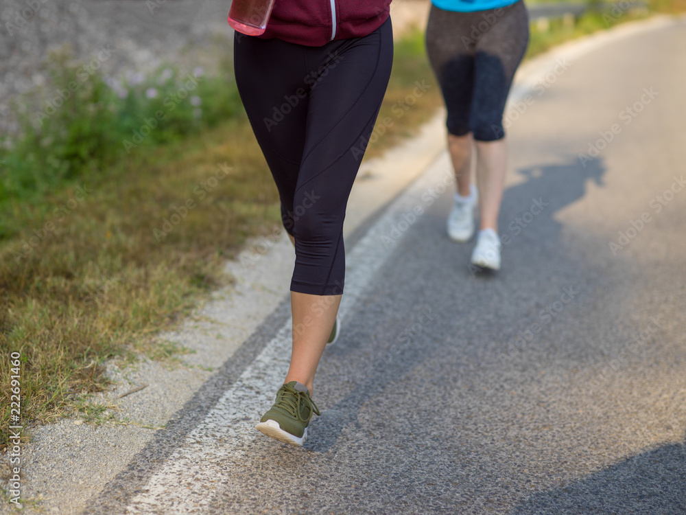 women jogging along a country road