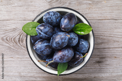 Fotografía Top view of a bowl full of ripe prune fruit on a wooden table