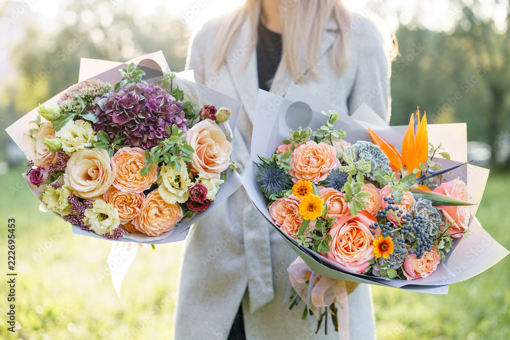 two beautiful spring bouquet. Young girl holding a flowers arrangements  with variety of colors. Violet, blue and peach color flower. Bright dawn or  sunset sun Stock Photo | Adobe Stock