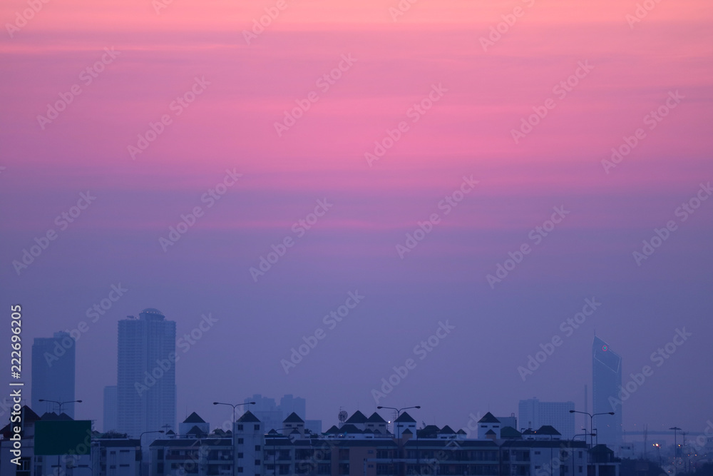 Beautiful purple blue sunset sky over the high buildings of Bangkok suburb, Thailand