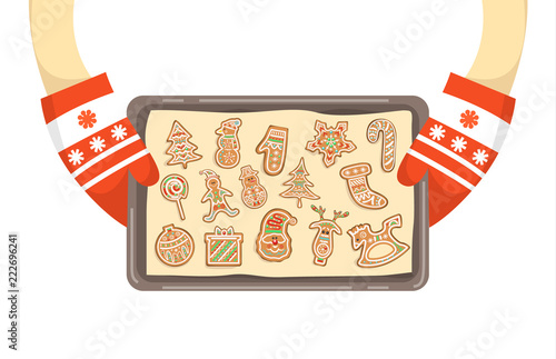 Hands in gloves holding tray with homemade cookies