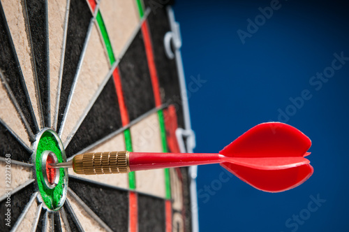 Close-up view of a red dart on the bullseye of a dartboard