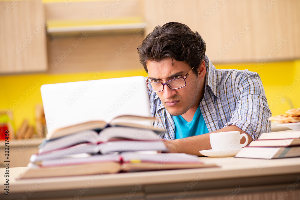 Student preparing for exam sitting at the kitchen Student preparing for exam sitting at the kitchen