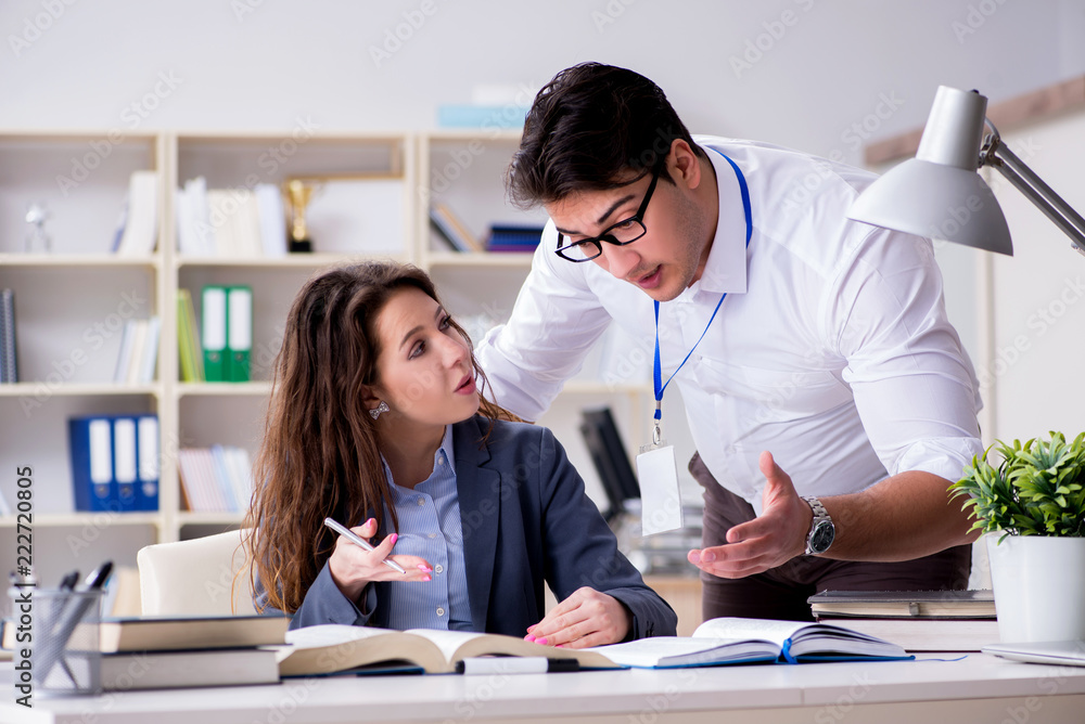 Teacher explaining to student at lecture Teacher explaining to student at lecture