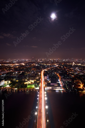 scenic of night cityscape with light tail of speed line on bridge