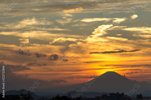 Golden sun setting behind the peak of mount Fuji