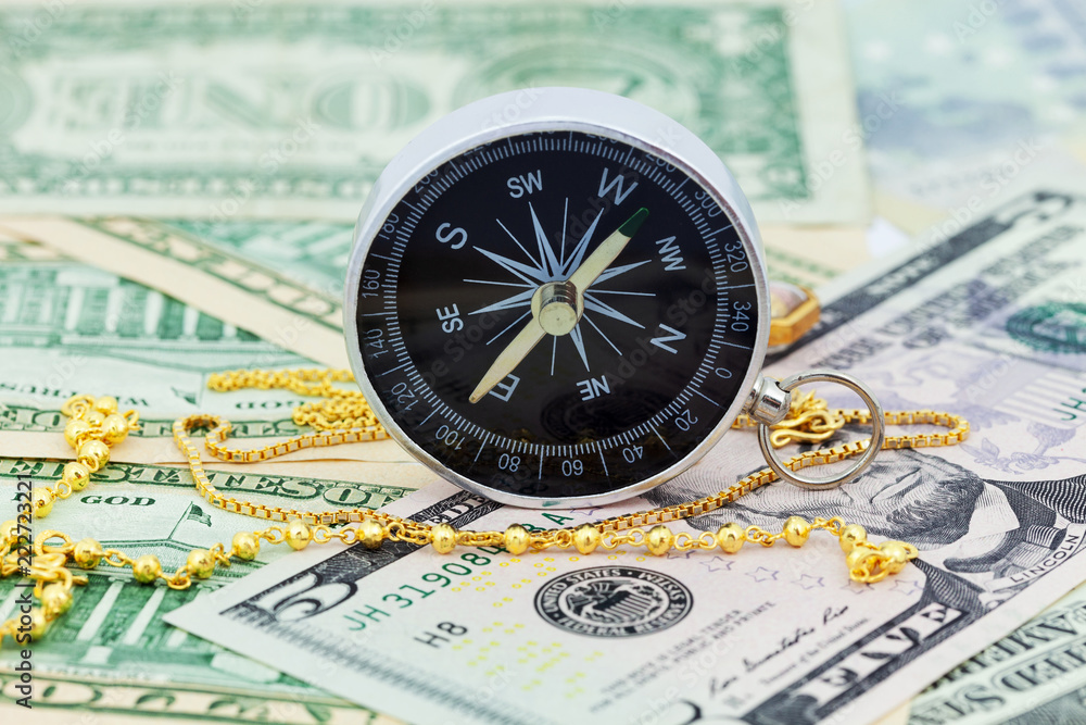 compass and gold necklace on money banknotes Euro and Dollars,concept of business planning and finance and savings. compass and gold necklace on money banknotes Euro and Dollars,concept of business planning and finance and savings.