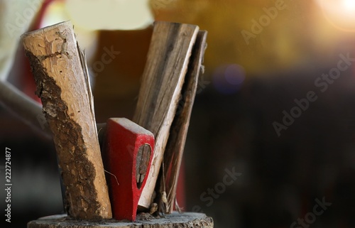 Axe splitting wood in two on chopping block