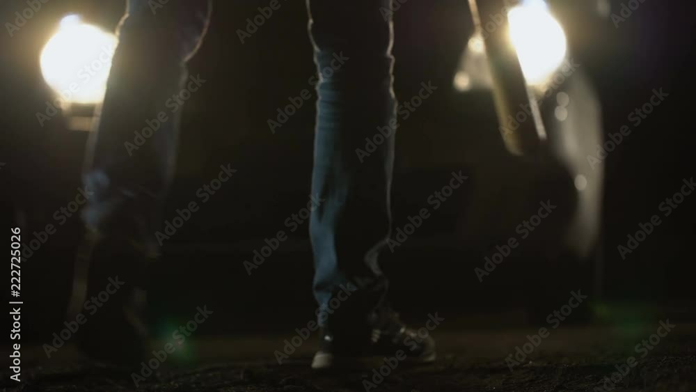 Angry criminal with baseball bat standing in front of car, illegal