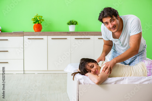 Man doing massage to his wife in bedroom 