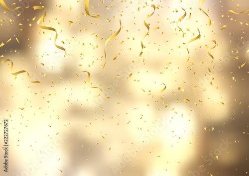 Gold confetti and streamers on defocussed background