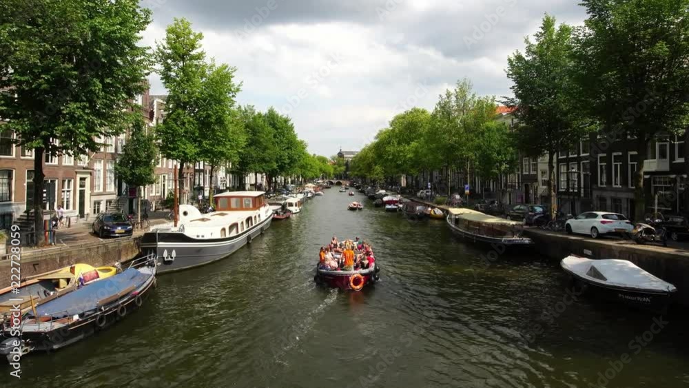 iconic Amsterdam canal with tourist boat, old houses and traditional boats iconic Amsterdam canal with tourist boat, old houses and traditional boats