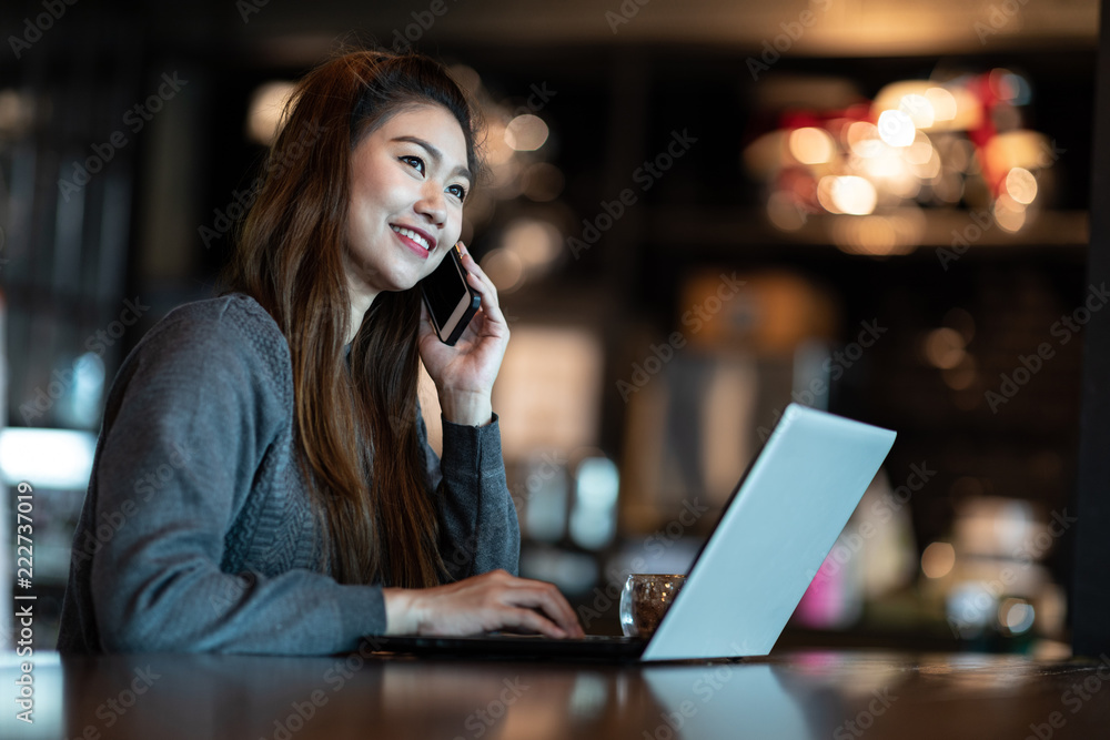 Beautiful Attractive Asian woman working with laptop smile and talking with customer in smartphone to get idea and requirement for success her job outside office in coffee shop cafe,Business Concept Beautiful Attractive Asian woman working with laptop smile and talking with customer in smartphone to get idea and requirement for success her job outside office in coffee shop cafe,Business Concept