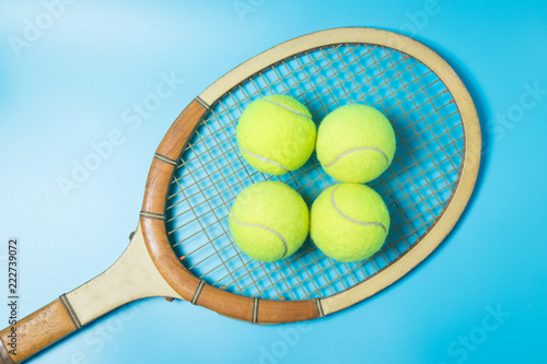 Tennis racket and balls on blue background. Sport equipment. Flat lay.