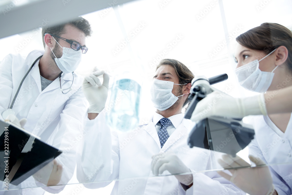 young scientists working with a microscope and test tubes young scientists working with a microscope and test tubes