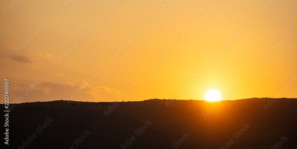 Sunset, sunrise over mountains silhouette. Scattered clouds on the sky background, space, banner.