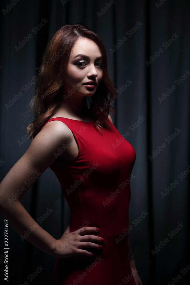 Girl in a red dress on a dark background Girl in a red dress on a dark background