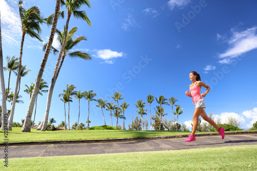 Girl jogging in park living an active summer. Runner woman running on sidewalk, healthy lifestyle.