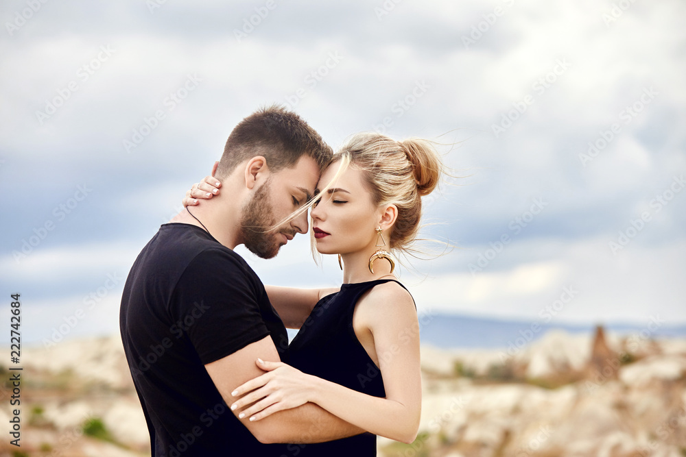 Love and emotions loving couple resting in Turkey. In love Eastern couple in the mountains of Cappadocia hugs and kisses. Close-up portrait of a man and woman. Beautiful Crescent earrings on girl ears Love and emotions loving couple resting in Turkey. In love Eastern couple in the mountains of Cappadocia hugs and kisses. Close-up portrait of a man and woman. Beautiful Crescent earrings on girl ears