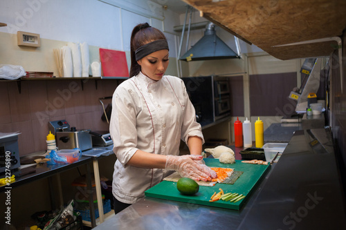 Photography woman Cook prepares sushi on restaurant kitchen