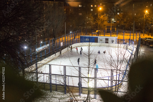 Photography Children and adults skate at the ice rink on a winter evening