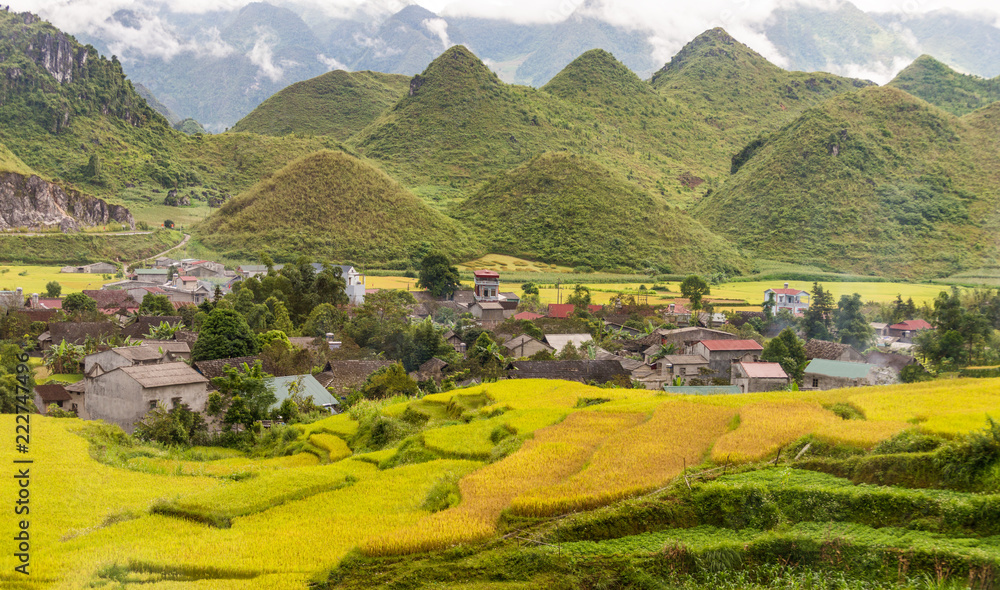 View of small village Fairy bosom in Tam Son town, Quan Ba District, Ha Giang Province, Vietnam.  colorful mixture of paddy fields and house roofs.Twin mountain,double mountain